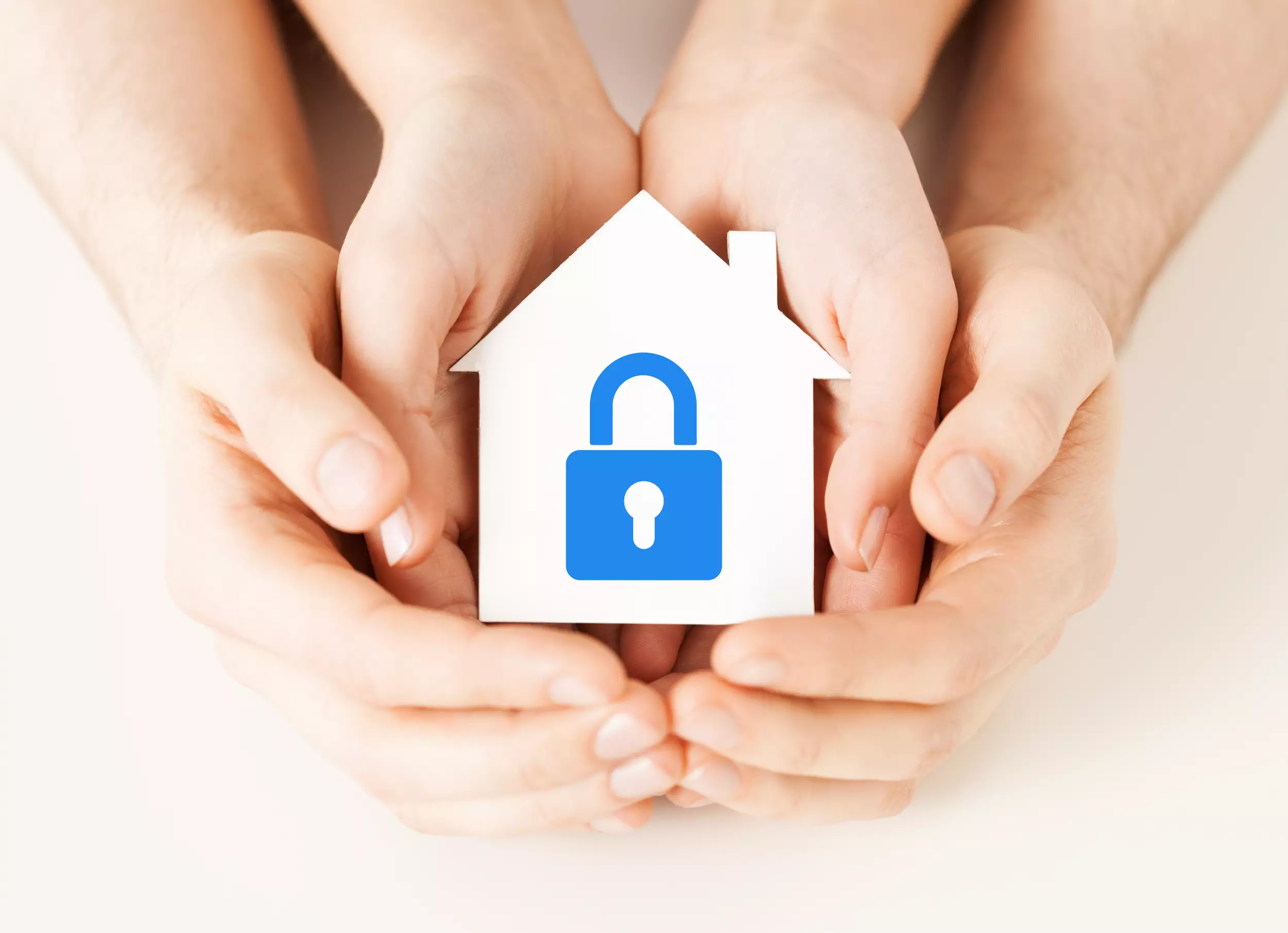 A family of hands holding a model home with a lock on it